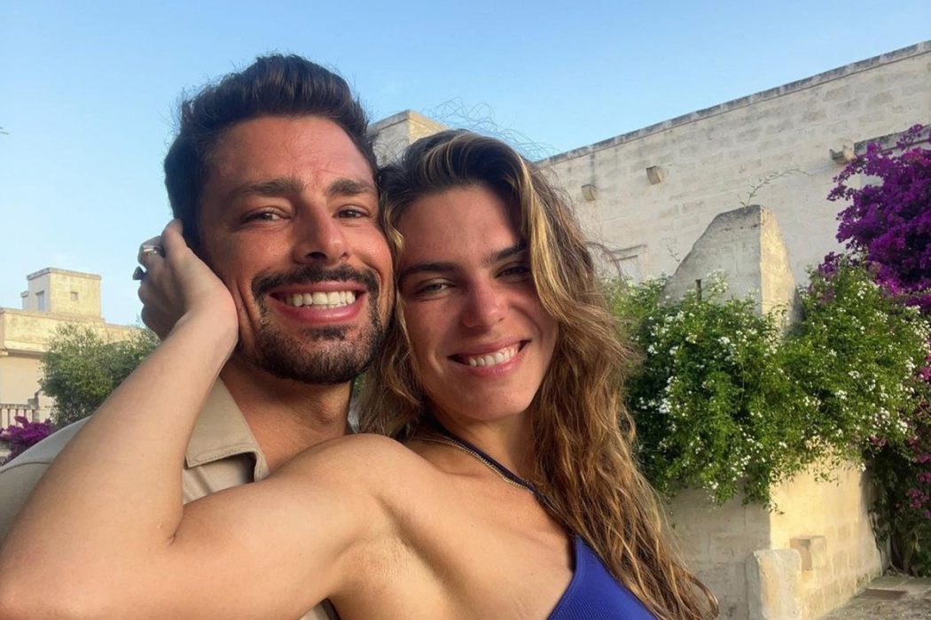 Cauã Reymond posa sorridente e coladinho Mariana Goldfarb