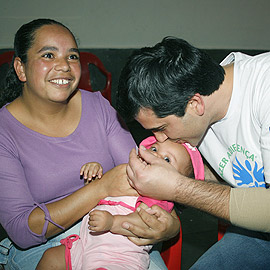 Du Guedes vacina uma criança