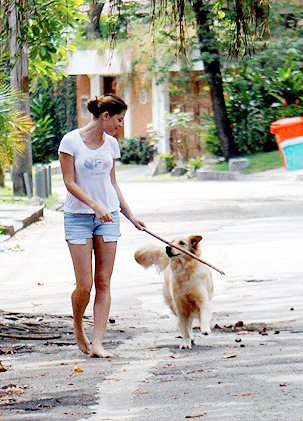 Alinne caminha descalça com seu cachorro