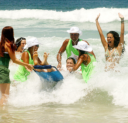 Na cena, as irmãs de Luciana, Mia e Isabel, acompanham a ex-modelo em seu banho de mar