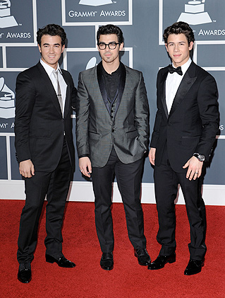 Os Jonas Brothers posaram juntos para os fotógrafos, na entrada do evento, no Staples Center, em Los Angeles