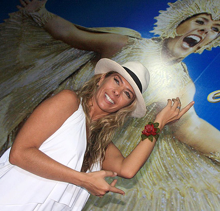Adriane Galisteu posa ao lado de sua foto como Rainha de Bateria da Unidos da Tijuca