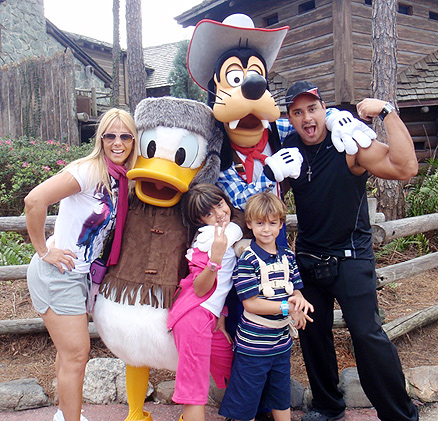 Família posa para foto ao lado dos personagens Pato Donald e Pateta