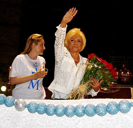 Emocionada, a apresentadora acena aos fiéis