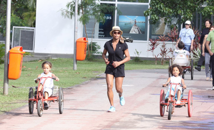 Adriana Bombom corre, enquanto as filhas pedalam, no Rio