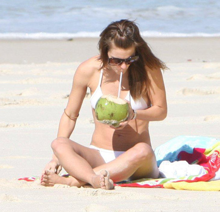 A atriz aproveita para se refrescar tomando uma água de coco