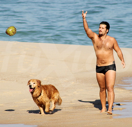 Bruno Gagliasso brinca com cachorro na praia