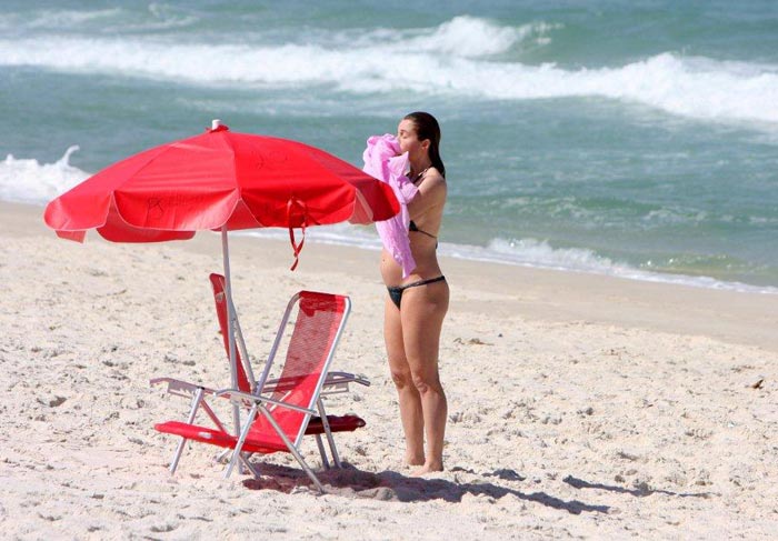 Letícia Spiller mostrou a barriguinha de quatro meses na praia