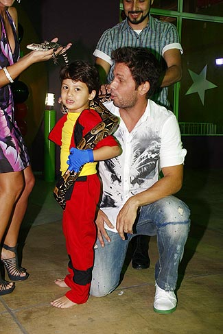 Ao lado do pai, Miguel brinca com uma cobra