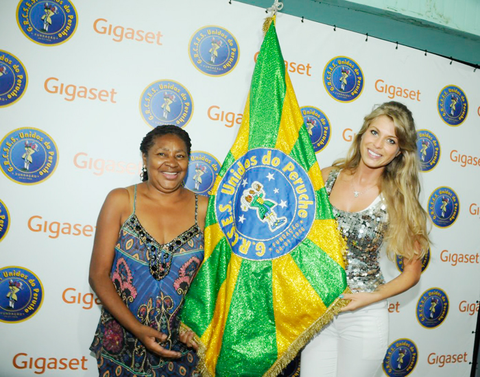 Caroline Bittencourt mostra a bandeira da escola de samba Unidos do Peruche