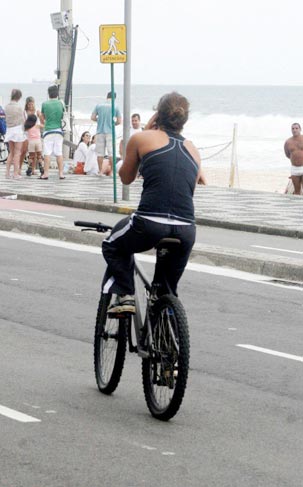 Ela segue de bicicleta falando ao celular