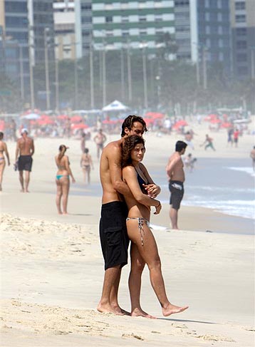 O casal aproveita o dia de sol para namorar na areia