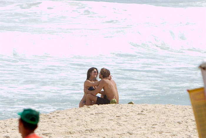 O casal troca carinho e beijos na praia