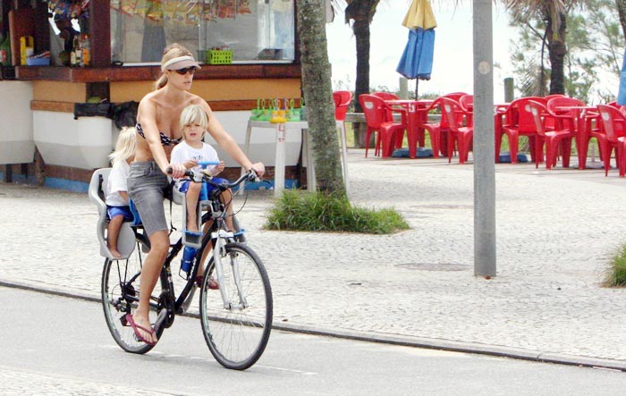 ...Fernanda volta do pesseio levando João e Francisco na garupa de sua bicicleta