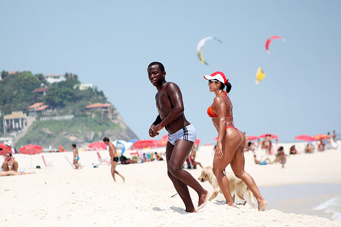 Dançarina saiu do mar segurando o cachorro pela coleira 