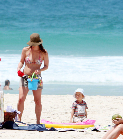 A mamãe zelosa brincou na areia com o primogênito