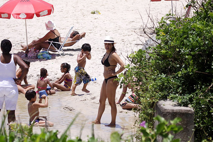 Atriz observa o filho Miguel enquanto ele brinca na areia