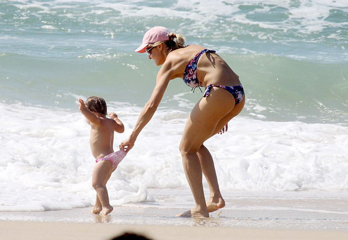 Bianca puxa a filha que corre em direção ao mar