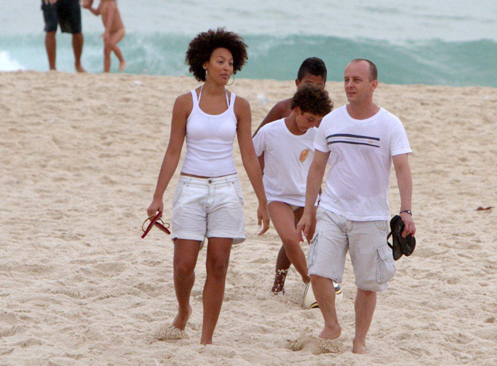 Sheron Menezzes caminha na areias com um grupo de amigos
