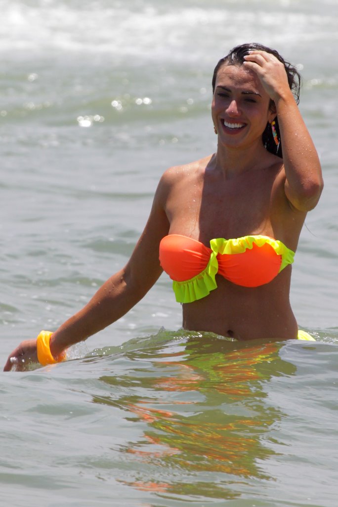 Nicole Bahls chama atenção com seu biquíni neon na praia 
