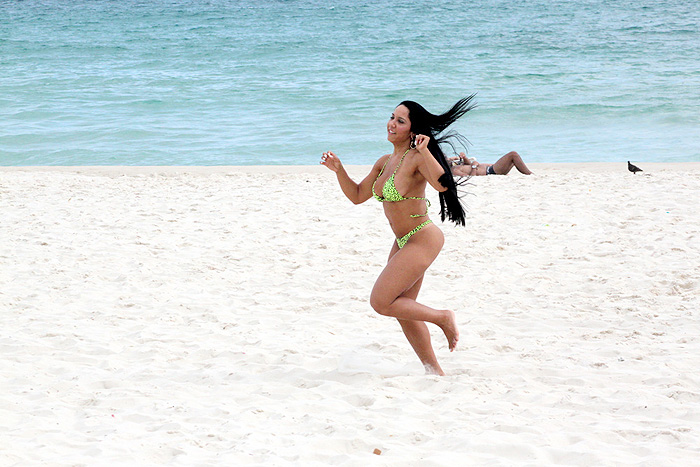 A morena corre pela areias da praia