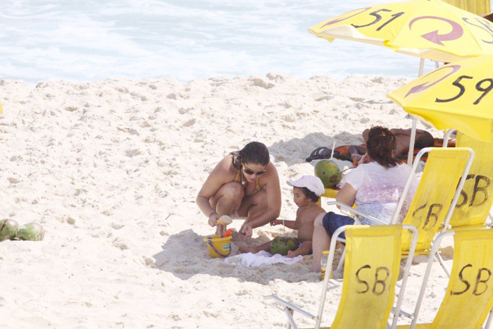 A mamãe zelosa brincou na areia com a pequena