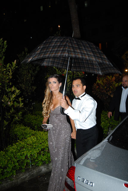 Luciano segura o guarda-chuva para não molhar a mulher