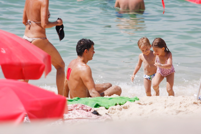 Eduardo Moscovis apareceu na praia com duas faixas vermelhas nas costas