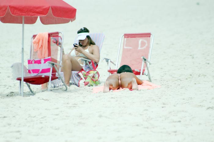 Ela relaxa na areia ao lado da amiga