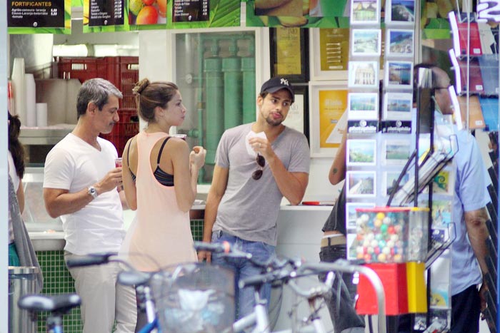 Os atores comem um sanduíche no balcão