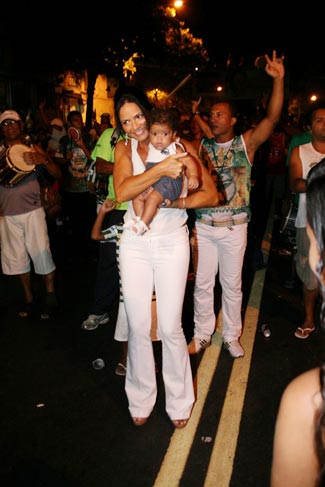 A beldade pega uma criança no colo para tirar uma foto com ela