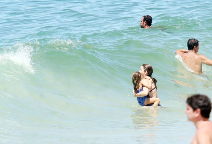 Cláudia Abreu curte praia acompanhada da família