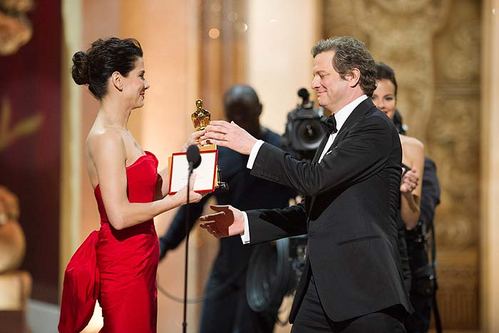 Colin Firth venceu como Melhor Ator pelo papel do monarca George VI em O Discurso do Rei e recebeu o prêmio das mãos de Sandra Bullock.