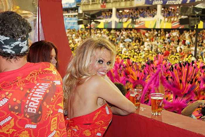 Pamela Anderson saboreia uma cerveja no camarote