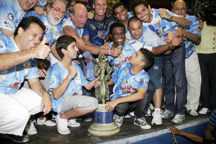 Neguinho da Beija-Flor e Carlinhos de Jesus posaram com outros integrantes da escola, com o troféu de campeã