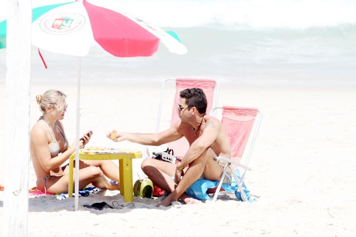 Latino em clima de romance com loira na praia