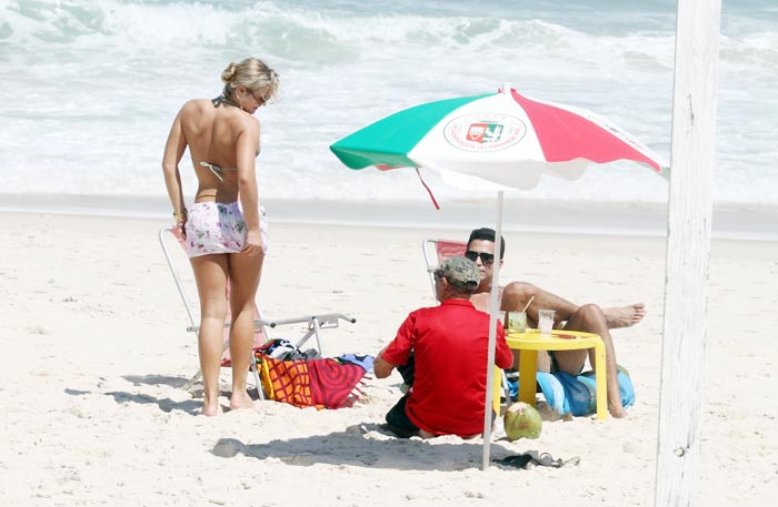 Latino em clima de romance com loira na praia