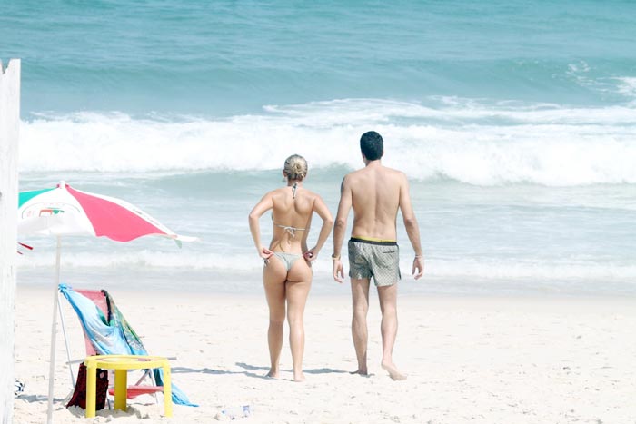 Latino em clima de romance com loira na praia