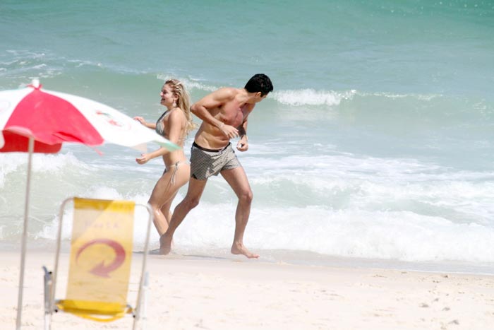 Latino em clima de romance com loira na praia