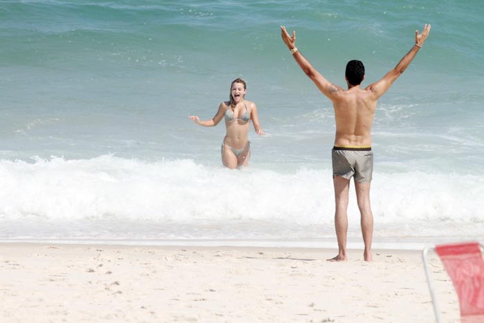 Latino em clima de romance com loira na praia