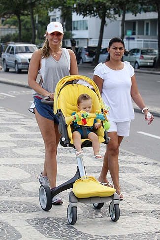 A mamãe sorridente, amparada pela babá, não escondia a felicidade