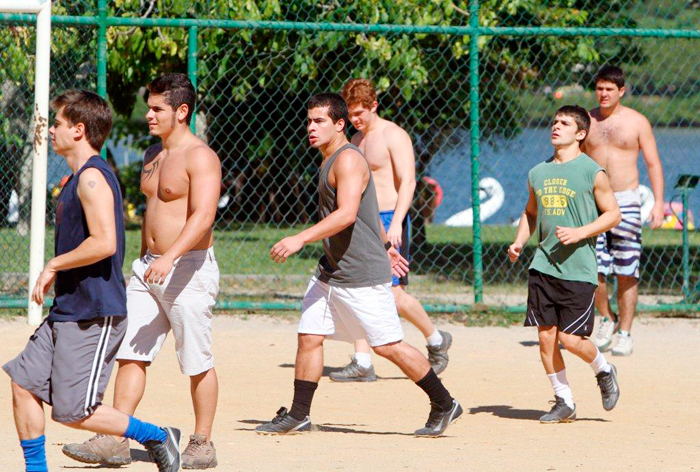 Os atores se enturmam com os figurantes para uma partida de futebol