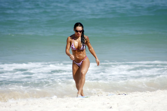 Namorada de Alexandre Frota se refrescou dando um mergulho no mar