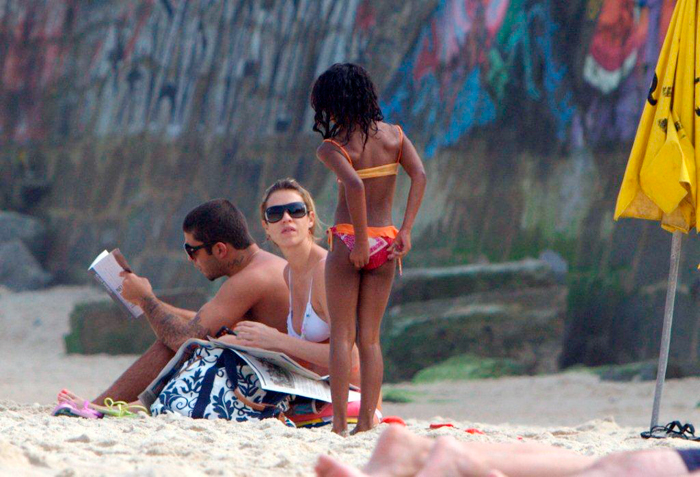 Casal lia enquanto afilhada se divertia na praia. 