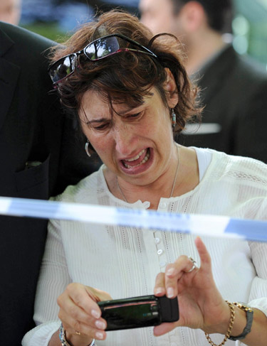 Pais choram ao ver homenagens dos fãs diante da casa de Amy Winehouse