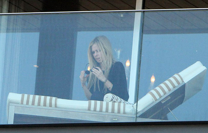 Avril Lavigne relaxa na sacada de hotel, no Rio - agnews