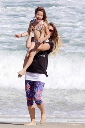 Susana Werner brincou com filha na praia. 