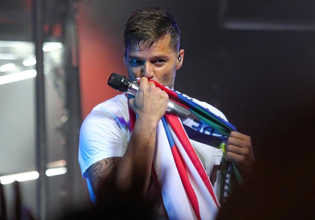 Ricky Martin beija uma bandeira de Porto Rico e Brasil