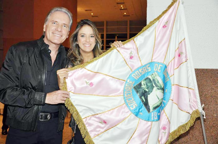 Justus e Ticiane mostram a bandeira da escola