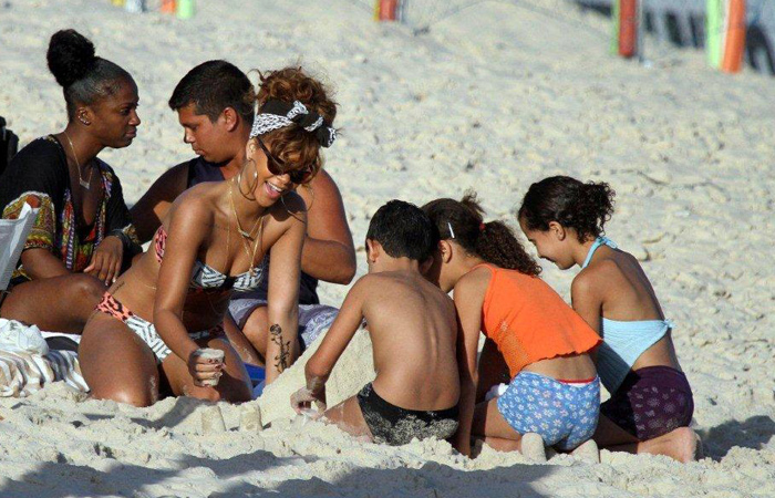 Simpática, a cantora brincou com algumas crianças que estava na praia, aonde chegou a fazer um castelo de areia.